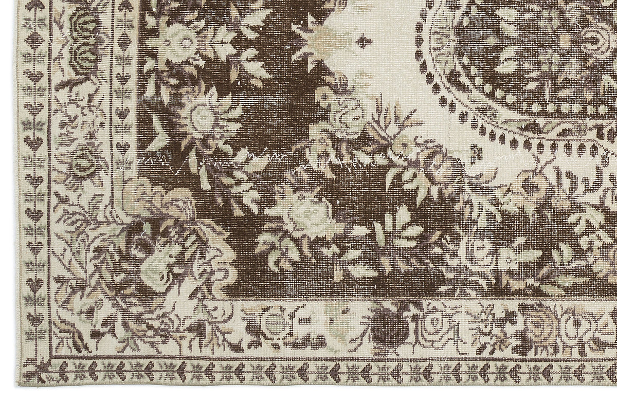 Brown and cream distressed rug with a traditional floral medallion pattern and ornate border.