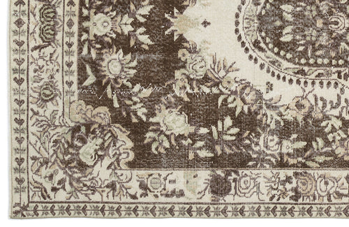 Load image 1 in gallery view. Brown and cream distressed rug with a traditional floral medallion pattern and ornate border.