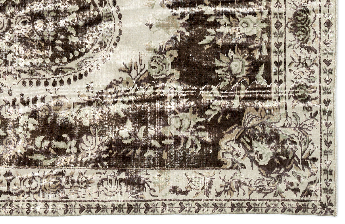 Dark brown and cream traditional rug with a distressed floral medallion pattern and ornate border.