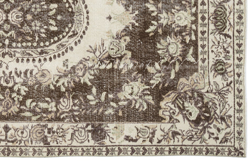 Load image 1 in gallery view. Dark brown and cream traditional rug with a distressed floral medallion pattern and ornate border.