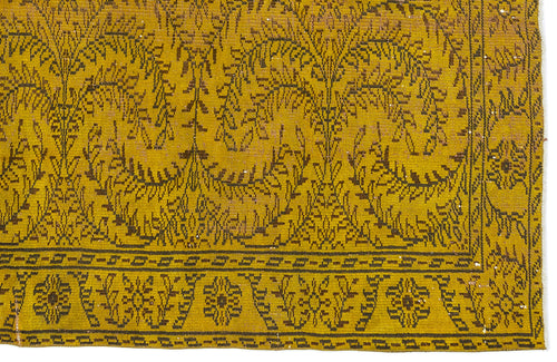 Load image 1 in gallery view. Mustard yellow rug with a dark brown botanical leaf pattern and a geometric border.