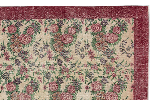 Load image 1 in gallery view. Distressed beige rug with a floral pattern in red, green, and purple, featuring a wide solid red border.