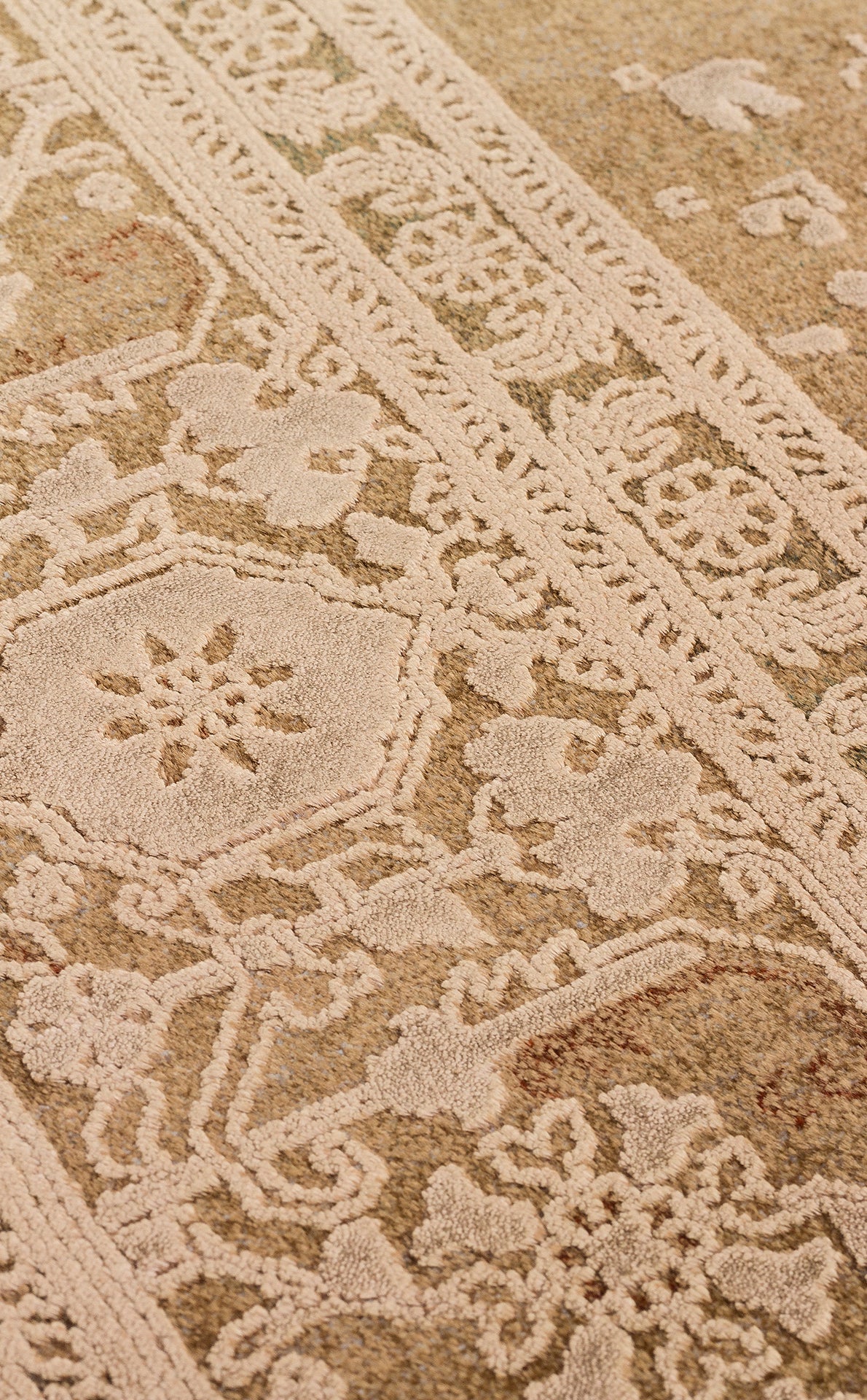 Tan and cream rug with a raised, tufted traditional floral medallion pattern and a decorative border.