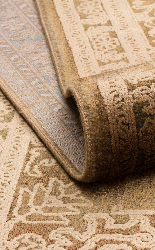 Load image 1 in gallery view. Folded tan and beige rug featuring a traditional ornate floral pattern with a visible woven edge.