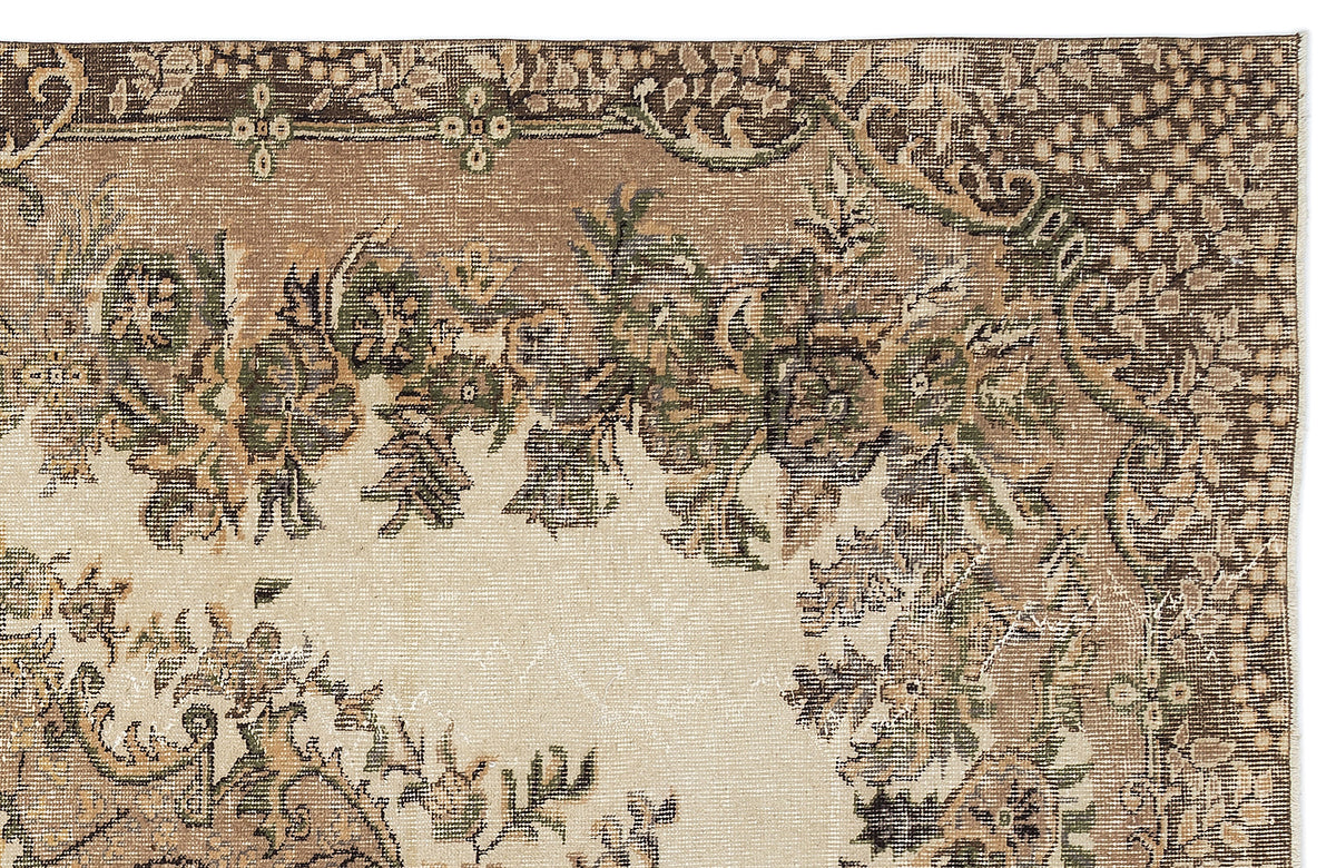 Beige, brown, and olive green traditional rug with a distressed floral medallion pattern on a white background.