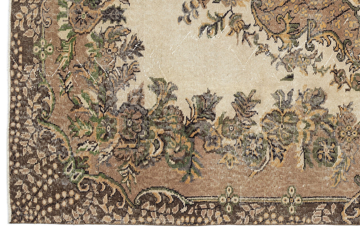 Distressed beige, brown, and green rug with a traditional floral medallion pattern and ornate border.