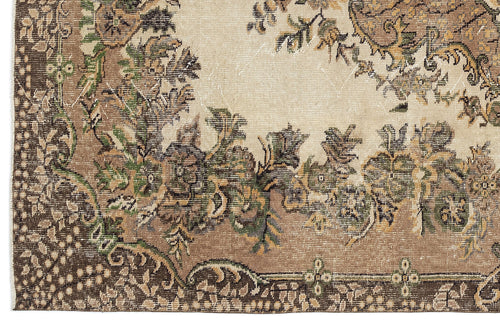 Load image 1 in gallery view. Distressed beige, brown, and green rug with a traditional floral medallion pattern and ornate border.