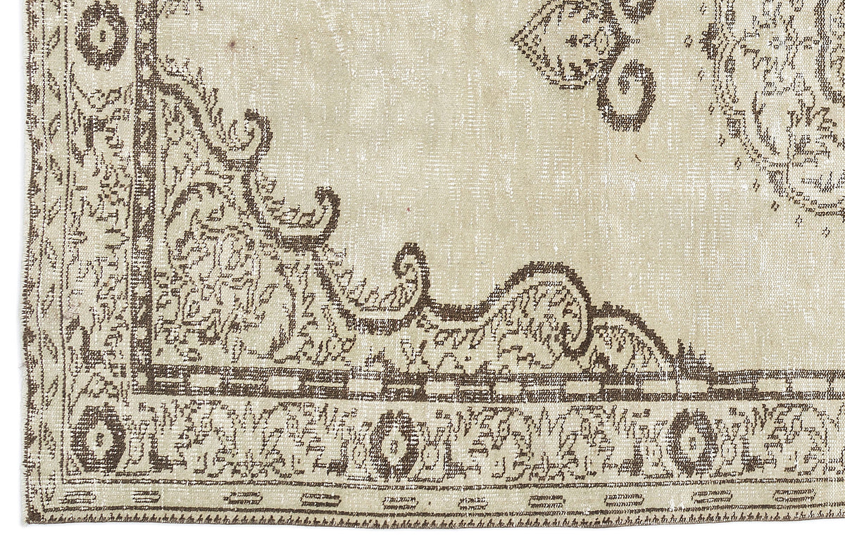 Beige and brown distressed rug with a traditional ornate medallion and border pattern.