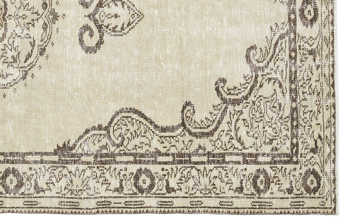 Beige and brown rug with a distressed traditional medallion pattern and a detailed geometric border.