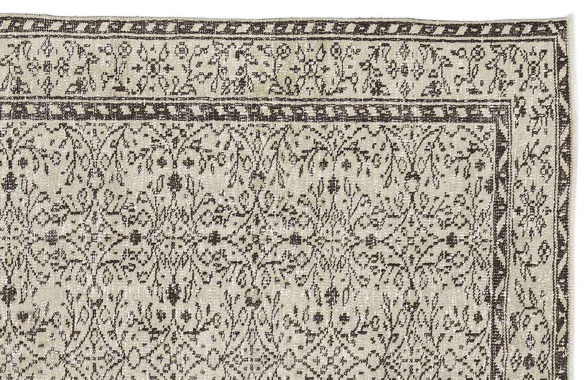 Beige and dark brown rug with a distressed floral medallion pattern and a geometric border on a white background.
