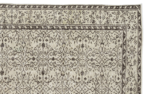 Load image 1 in gallery view. Beige and dark brown rug with a distressed floral medallion pattern and a geometric border on a white background.