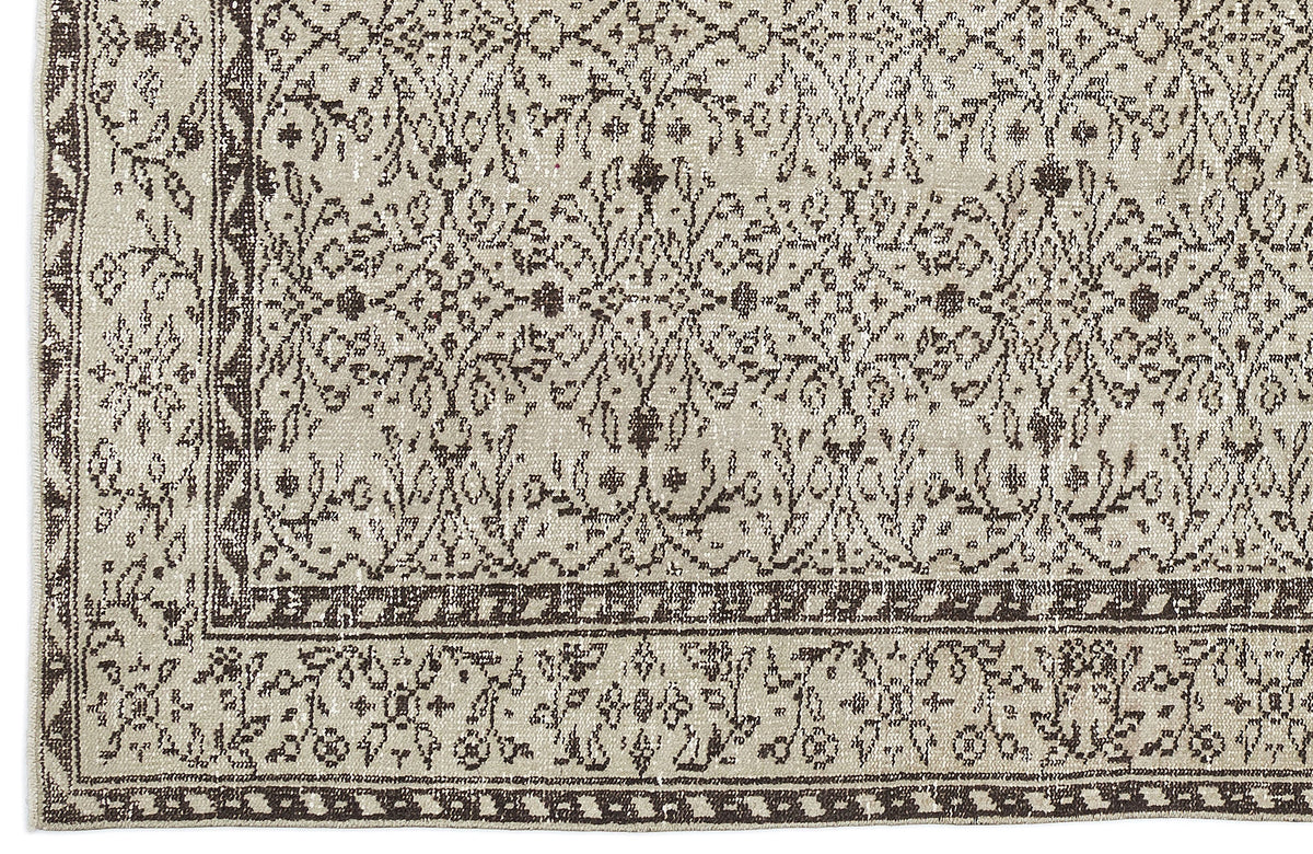 Beige and dark brown rug with a distressed traditional floral medallion pattern and a geometric border.