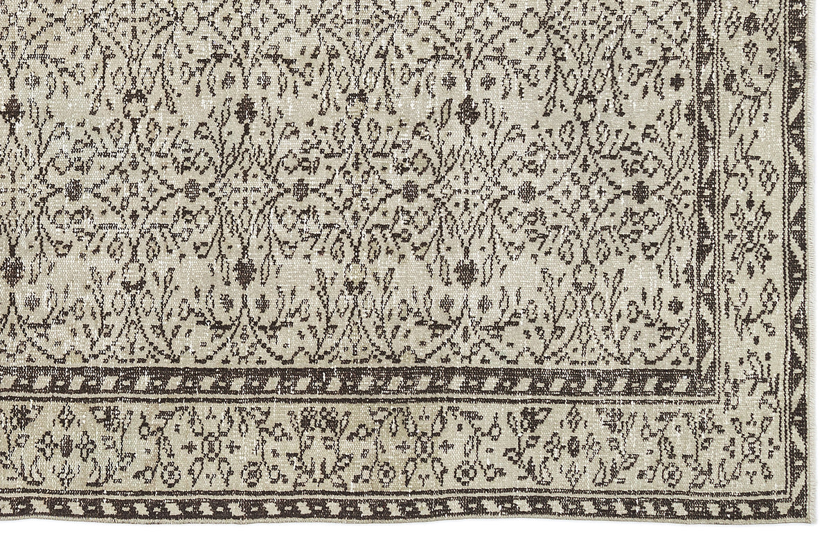 Beige and dark brown rug with a distressed traditional floral pattern and a geometric border.