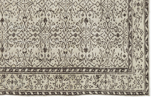 Load image 1 in gallery view. Beige and dark brown rug with a distressed traditional floral pattern and a geometric border.