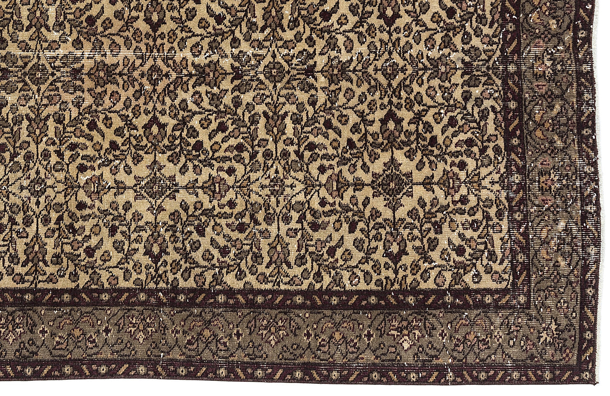 Tan and dark brown traditional rug with an intricate floral vine pattern and a wide, detailed border.