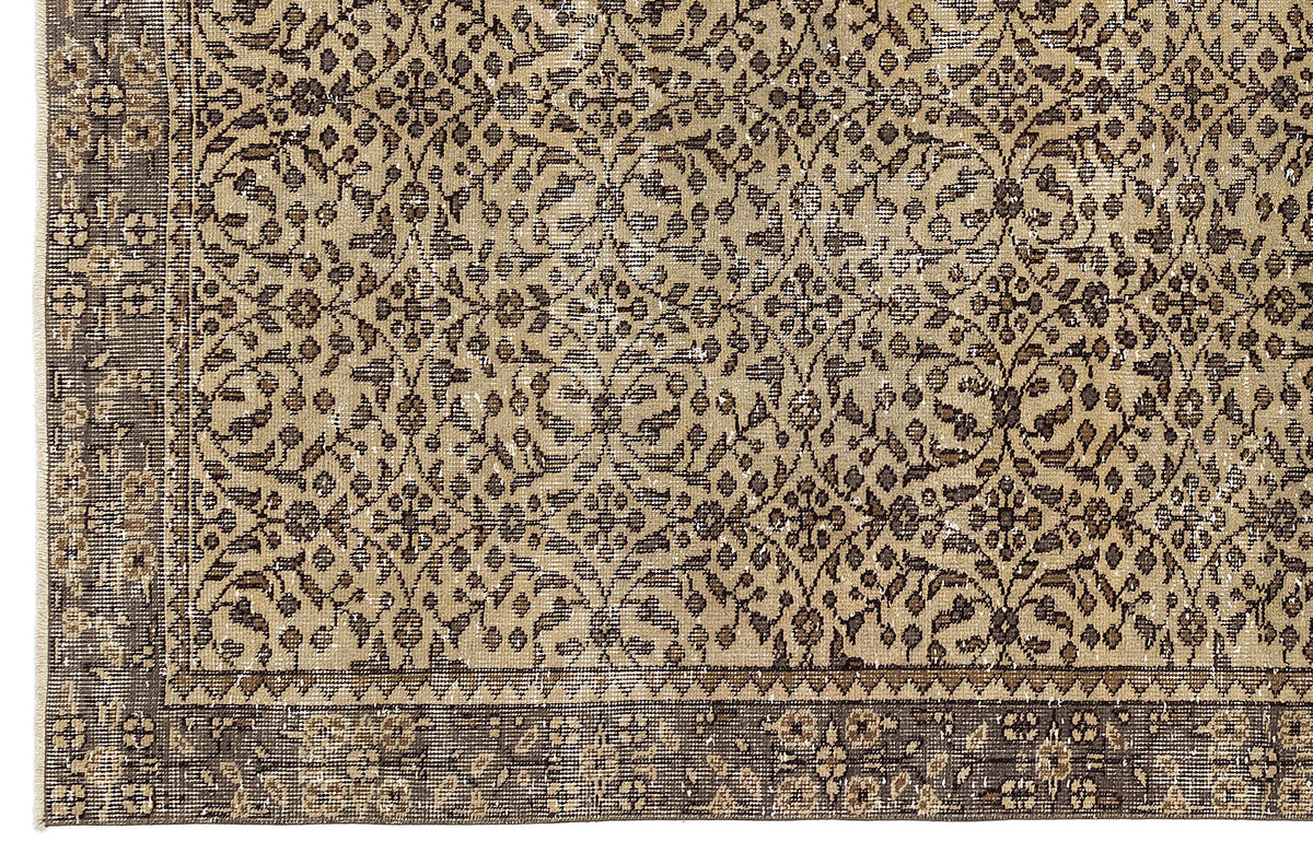 Tan and dark brown rug with a distressed, traditional floral vine pattern and a wide decorative border.