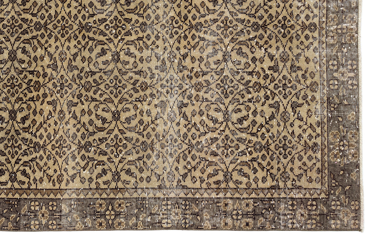 Tan and dark brown vintage-style rug with a repeating floral medallion pattern and a wide, detailed border.