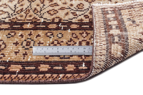 Load image 1 in gallery view. Brown and tan patterned rug with a folded corner showing the weave and a metal ruler for scale.