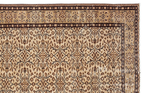 Load image 1 in gallery view. Tan and dark brown traditional rug with a dense floral vine pattern and a geometric border.