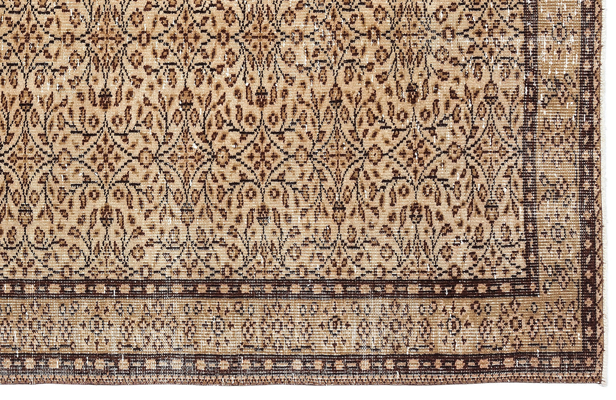 Tan and dark brown traditional rug with a distressed floral lattice pattern and a geometric border.
