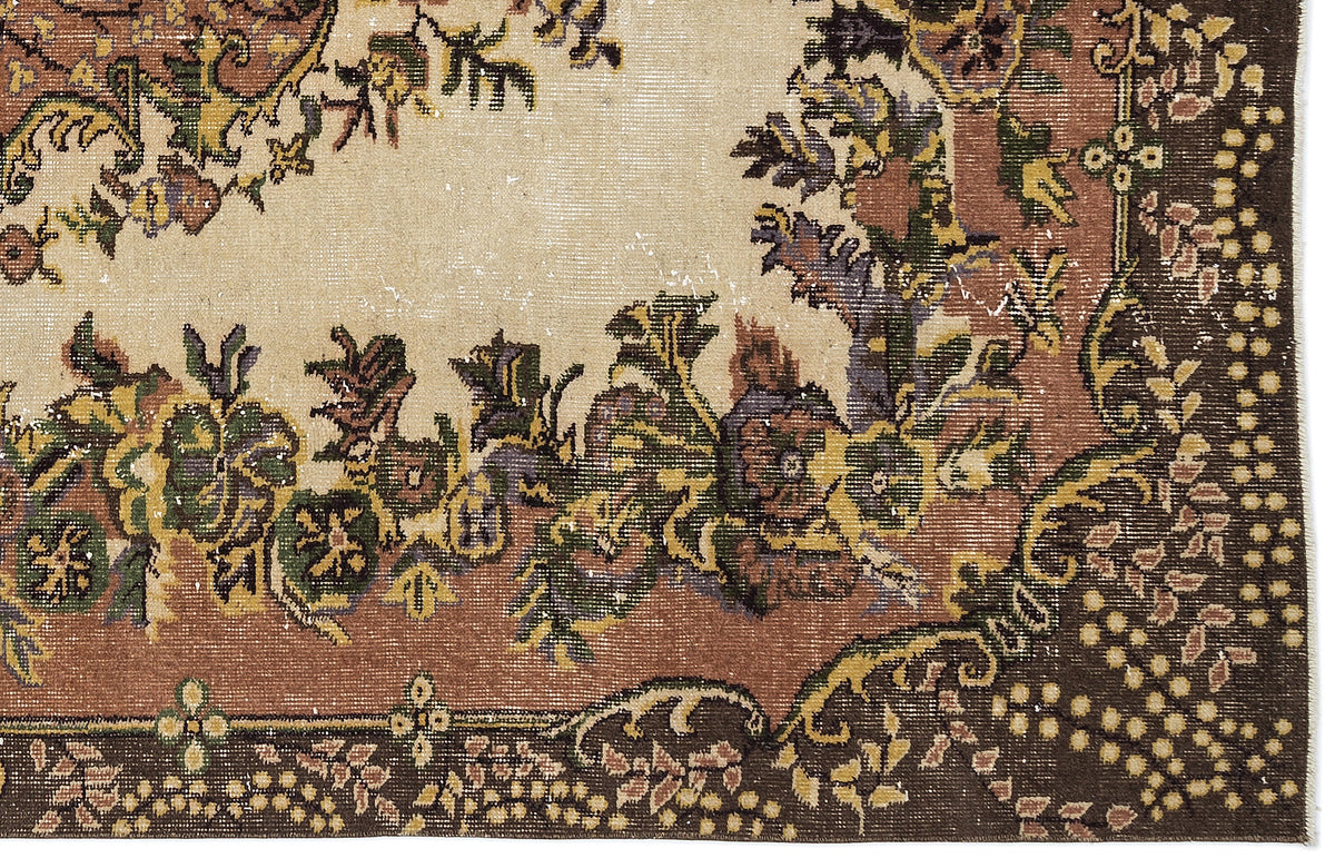 Distressed vintage-style rug with a cream center, brown border, and multicolored floral medallion pattern.
