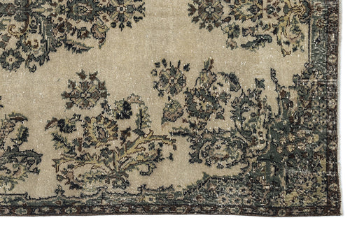 Load image 1 in gallery view. Beige rug with a distressed floral pattern in muted green, brown, and charcoal tones.