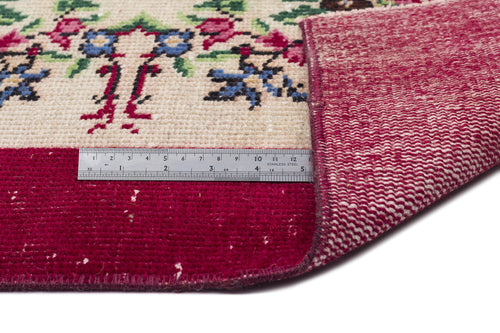 Load image 1 in gallery view. Cream rug with floral pattern and deep red border, shown folded to reveal the woven backing and a metal ruler.