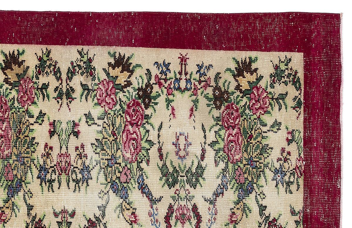 Beige rug with a deep red border and a multi-colored floral pattern featuring pink roses and green foliage.