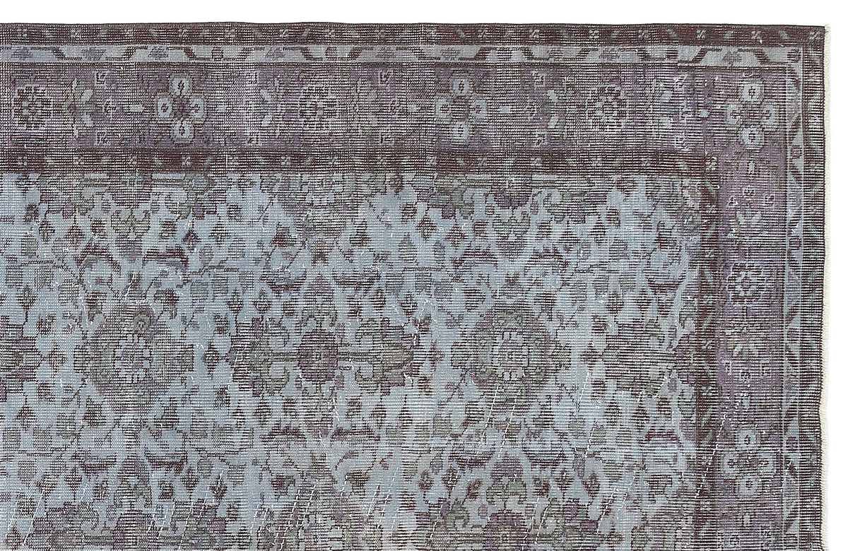 Charcoal and light blue distressed rug with a traditional floral medallion pattern and a wide decorative border.