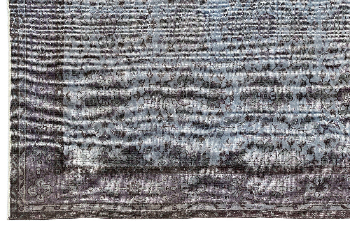 Slate blue and charcoal grey rug with a distressed traditional floral medallion pattern and a wide decorative border.