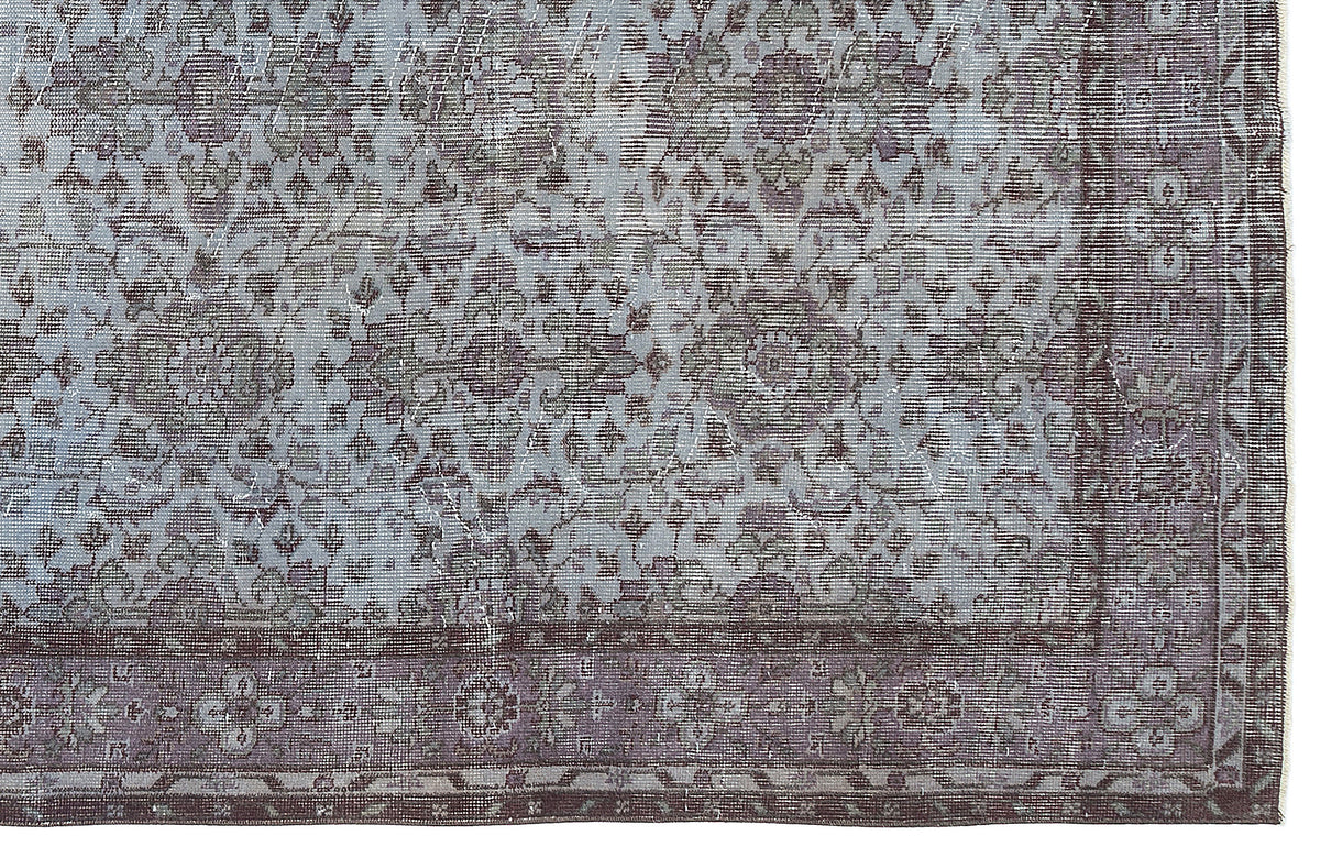 Distressed slate blue and charcoal grey rug with a traditional floral medallion pattern and a wide decorative border.