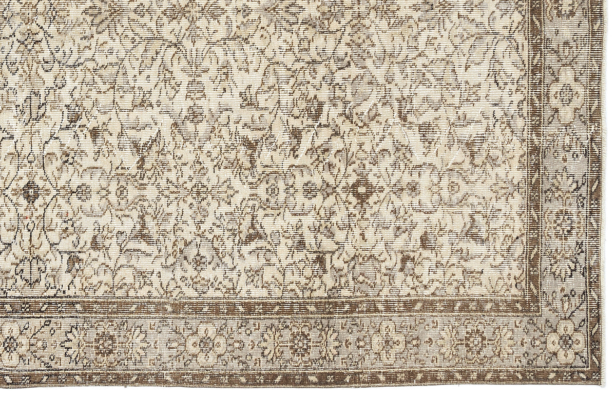 Beige and brown traditional rug with a distressed floral medallion pattern and a detailed border.
