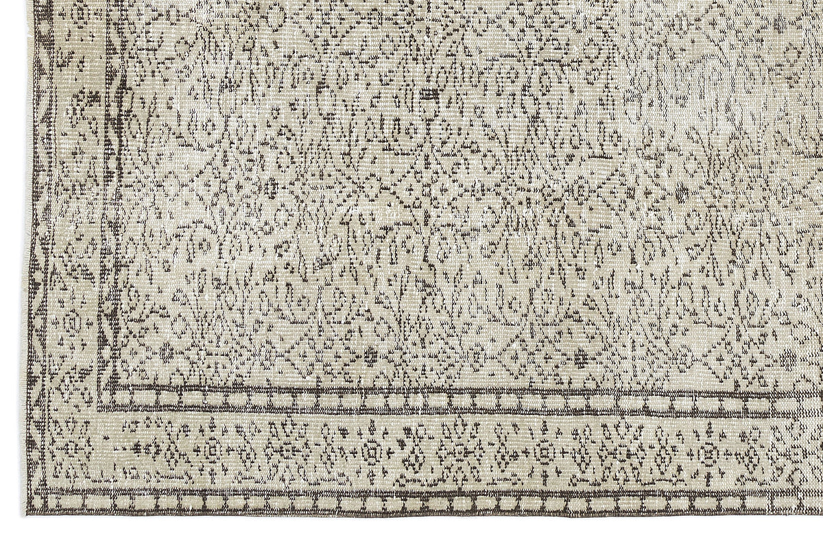 Beige and charcoal grey rug with a distressed traditional medallion pattern and a geometric border.