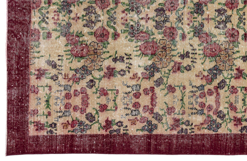 Load image 1 in gallery view. Beige rug with a distressed floral pattern in red, green, and blue, featuring a solid dark red border.