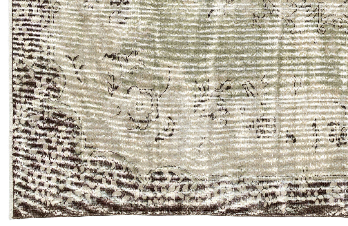 Sage green and brown distressed rug with a traditional floral medallion pattern and ornate border.