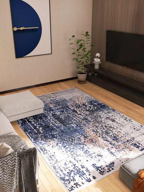 Load image 1 in gallery view. Modern living room featuring the Abstract Atmosphere - Washable Rug - JR834 in blue and white, a gray sectional, potted plant, wall-mounted TV, low black console, and framed geometric art. Light wood floors and neutral walls complete the look.