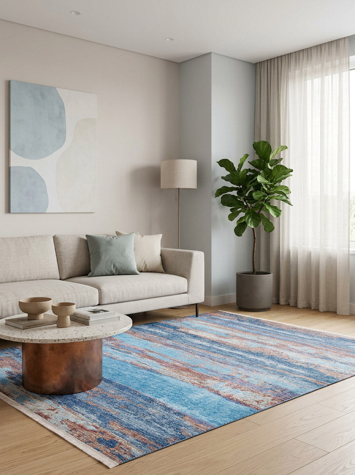 A modern living room with a beige sofa, blue and gray pillows, abstract wall art, floor lamp, potted plant, sheer curtains, round coffee table, and the Abstract Elegance - Machine-Washable Rug JR87 on a wooden floor.