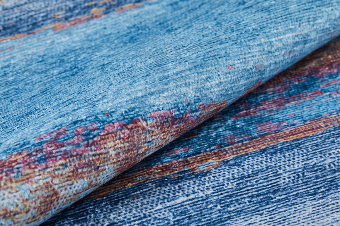 A close-up of Abstract Elegance - Machine-Washable Rug JR87 (Custom Size), folded to reveal intricate multicolored blue, red, and brown patterns—perfect for high-traffic areas and easy to wash.