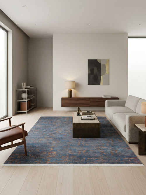 Bild 1 in Galerieansicht laden. Blue and copper distressed abstract rug with fringe edges, styled in a modern living room.