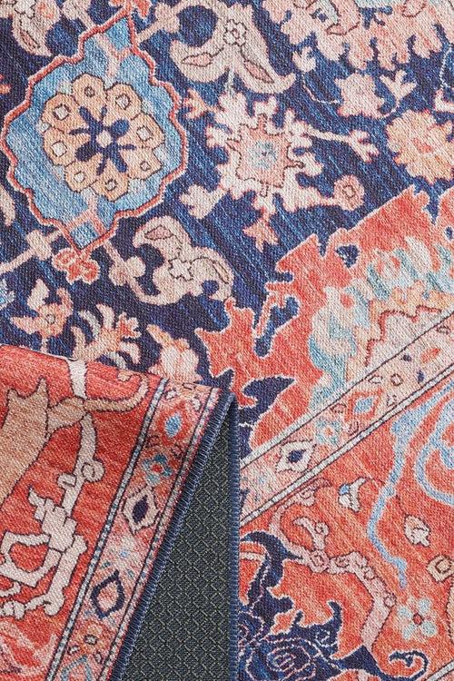 Bild 1 in Galerieansicht laden. A close-up of the Aegis Handmade-Design Washable Rug (LCC3029) shows vibrant blue, red, pink, and cream floral and geometric patterns. One corner is folded to reveal the backing—perfect for high-traffic areas.