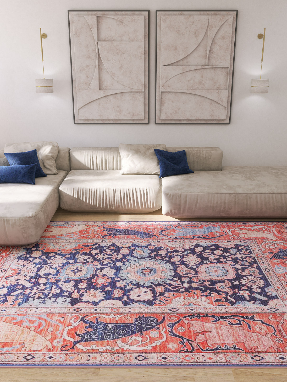 A modern living room featuring light beige sofas, blue accent pillows, abstract wall art, wall-mounted lights, and the Aegis Handmade-Design Washable Rug - LCC3029 (Custom Size) with vibrant red, blue, and pink patterns on the wooden floor.
