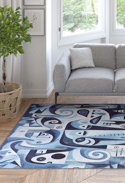 Load image 1 in gallery view. A modern living room with a gray sofa, patterned pillow, potted plant, wood floor, and the Aesthetic Anomaly Contemporary Washable Rug - MDJ004 (Custom Size) in blue—its geometric design is perfect for high-traffic spaces with views of lush greenery.