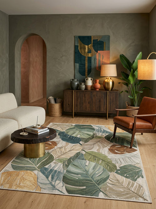 Load image 1 in gallery view. Green, gold, and beige rug with a large-scale tropical leaf pattern, styled in a modern living room.