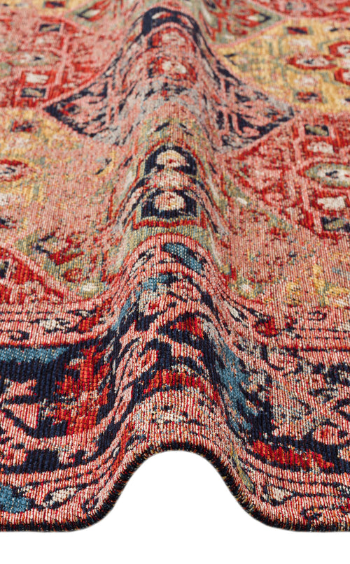 Load image 1 in gallery view. A close-up of the Anatolian Weave - Washable Kilims - AND01 showcases multicolour chenille polyester with red, navy blue, and tan geometric and abstract tribal patterns and a wave-like fold through the center