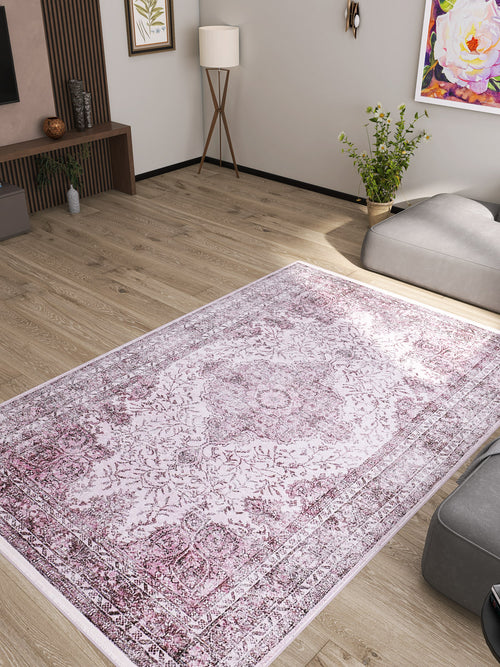 Load image 1 in gallery view. A modern living room with light wood floors, neutral walls, the Ancient Emblem - Washable Rug - JR200 (Custom Size) in pink and white, a floor lamp, plants, and colorful artwork on the walls.