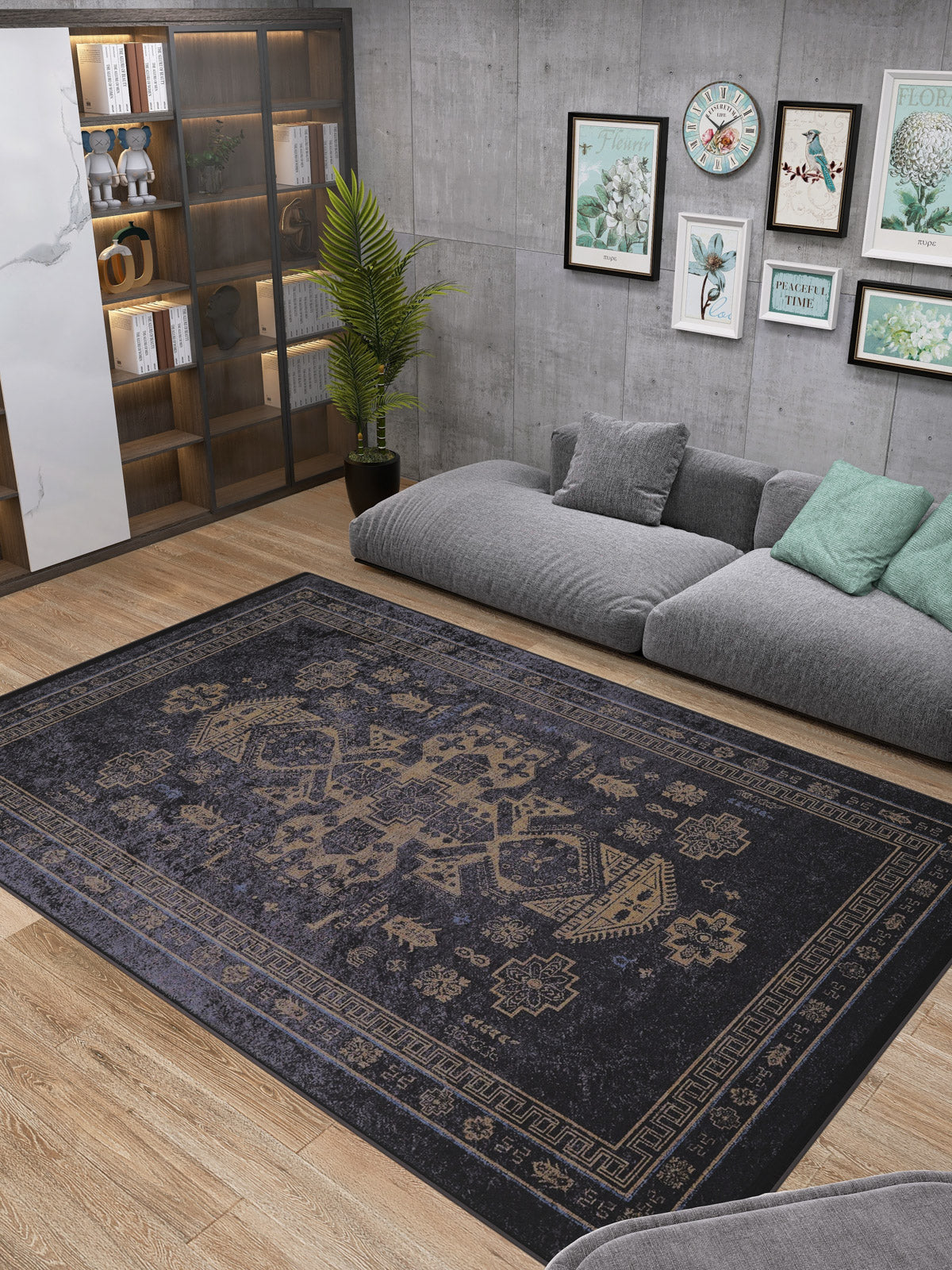Modern living room with a gray sectional, green and gray pillows, a plant, wooden shelves with decor, framed art on a concrete wall, and the Ancient Legacy - Washable Rug - JR1890 (Custom Size) in black.