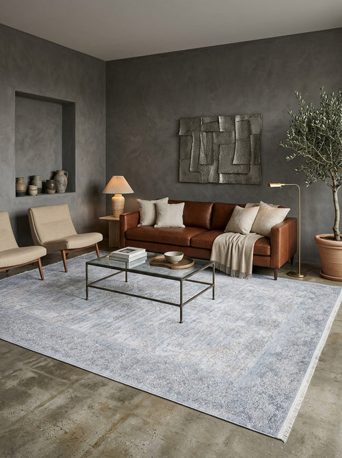 Load image 1 in gallery view. Light blue and grey distressed traditional rug with a faded medallion pattern, styled in a modern living room.