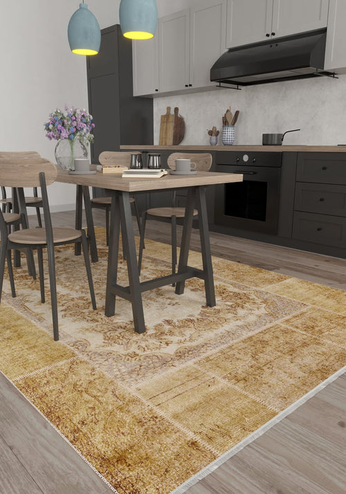 Load image 1 in gallery view. A modern kitchen with gray cabinets, black appliances, a dining table for four, purple flowers in a vase, and the Antique Insignia - Washable Rug - JR309—ideal for high-traffic areas—on the wooden floor. Two blue pendant lights hang above the table.