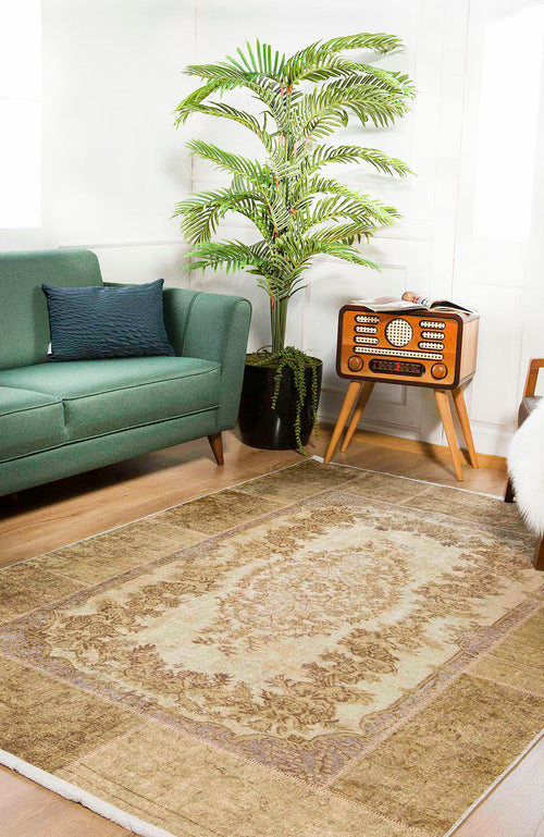 Load image 1 in gallery view. A cozy living room with a green sofa, vintage radio on a wooden stand, tall potted palm, and the Antique Insignia - Washable Rug - JR309 (Custom Size) in beige and brown—perfect for high-traffic wooden floors.