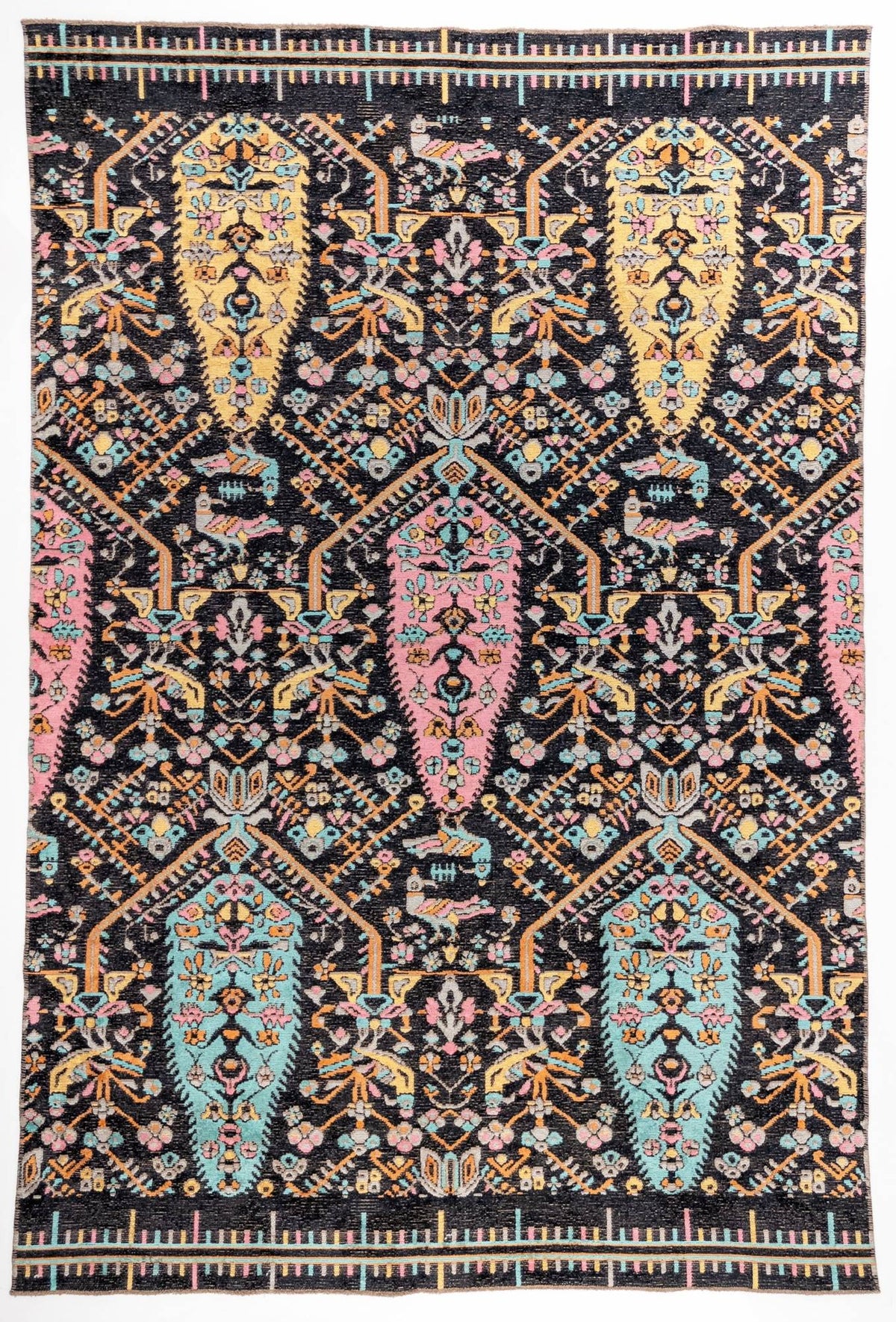 Midnight Bazaar area rug with black ground and vibrant pink, yellow, and turquoise paisley boteh motifs